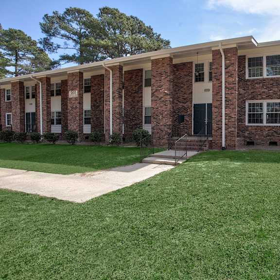 a brick building with a green lawn in front.