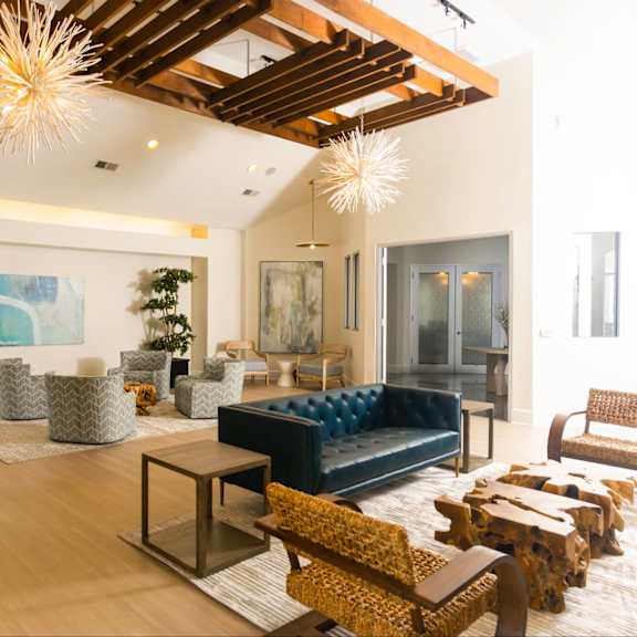 a living room with a blue couch and a wooden floor.