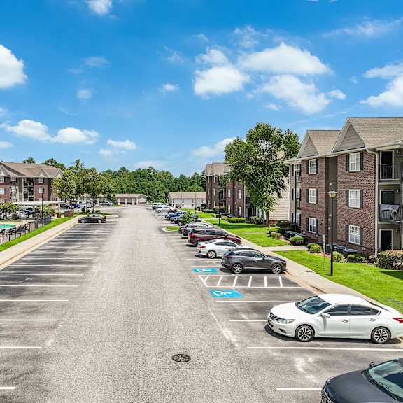 a street view of a residential area with cars parked on the side.