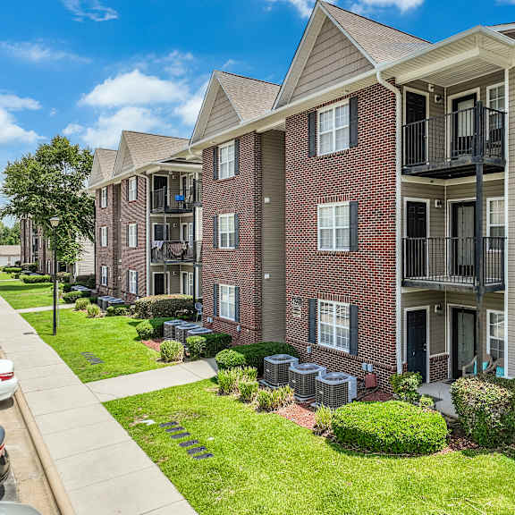 apartment complex with a car parked on the sidewalk.
