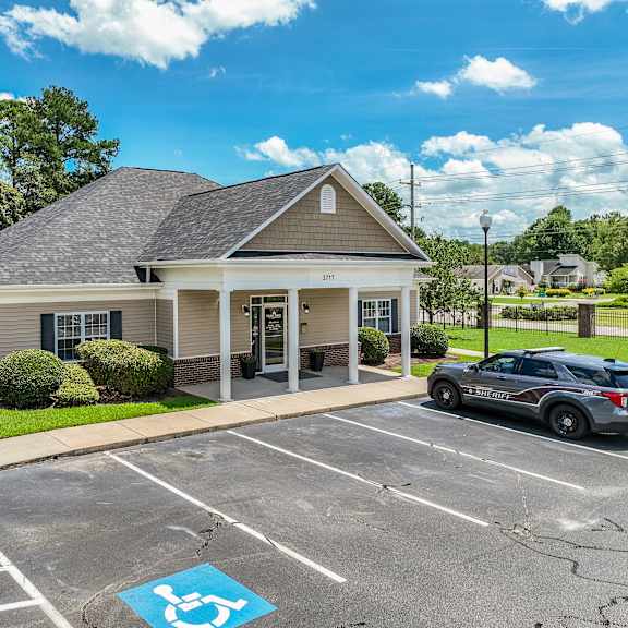 a small building with a parking lot in front of it.