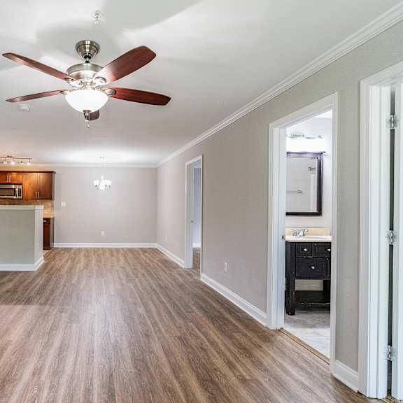 a room with a ceiling fan and wooden flooring.