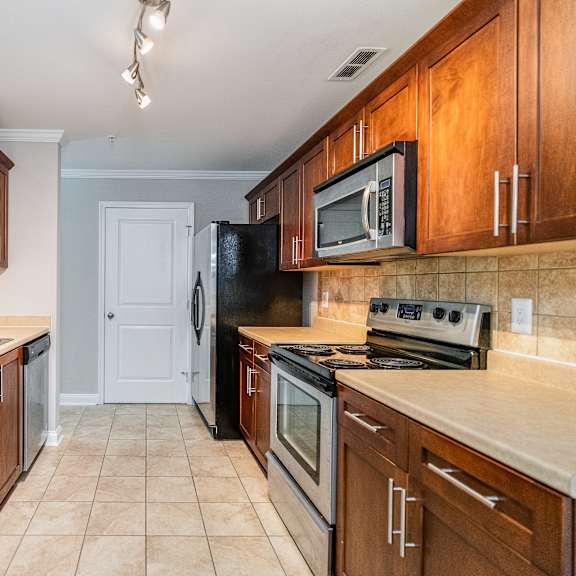 a kitchen with brown cabinets and a black refrigerator.