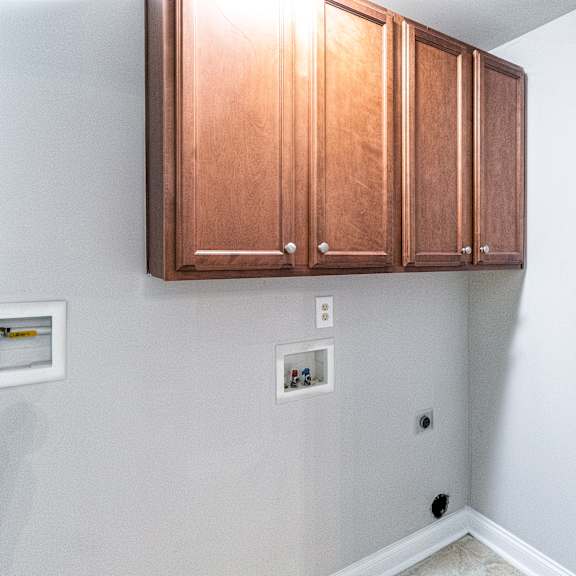 a white wall with a brown cabinet and a white switchboard.