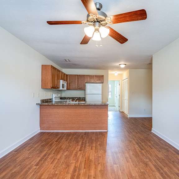 a room with a ceiling fan and wooden floors.