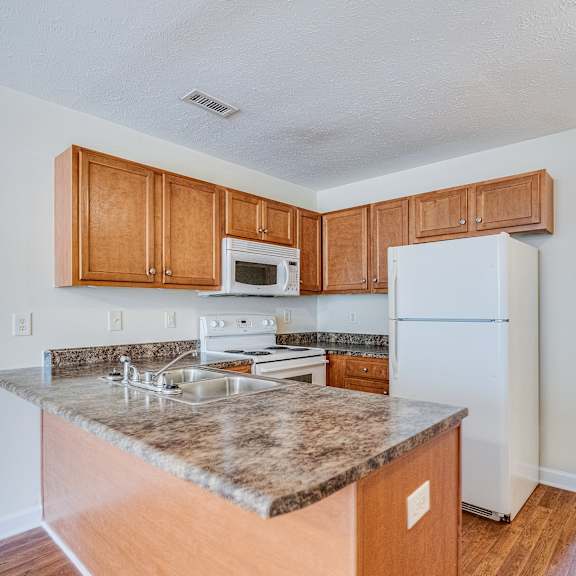 a kitchen with a granite countertop and wooden cabinets.