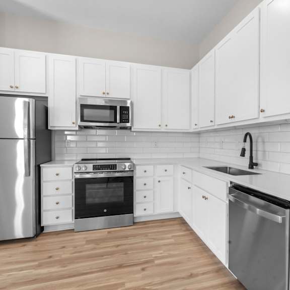 a kitchen with white cabinets and a stainless steel refrigerator.