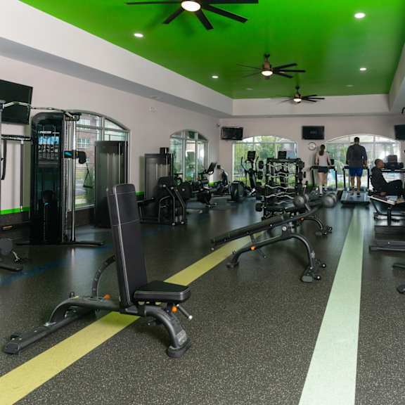 a gym with a variety of equipment including treadmills, weights, and exercise machines.