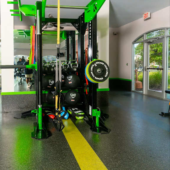 a gym with a green and black weight rack.
