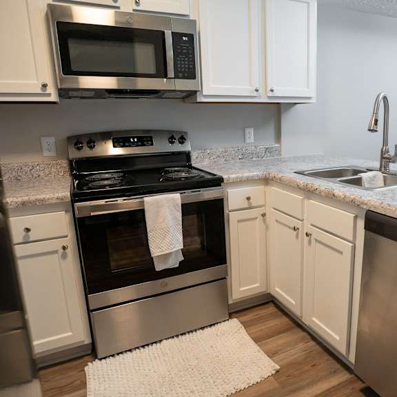 a modern kitchen with a stove top oven and a microwave above it.