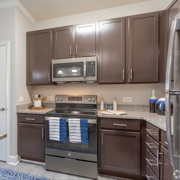 a kitchen with brown cabinets and stainless steel appliances.