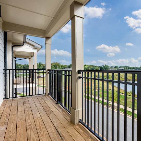 a balcony with a black railing and a view of a body of water.