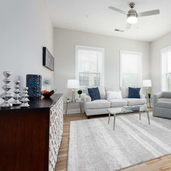 a living room with a white couch, a grey armchair, and a coffee table.