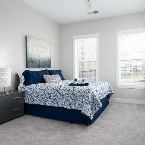 a bedroom with a bed, nightstands, and a plant.