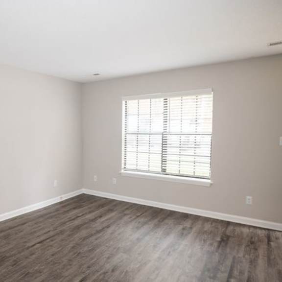 a room with a window and wooden flooring.