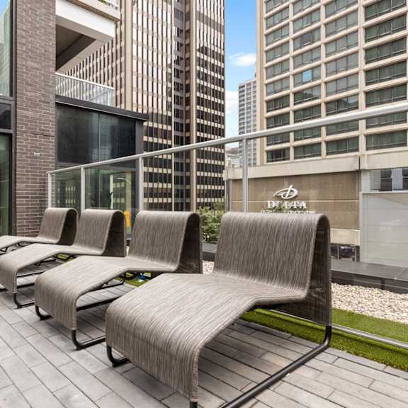 a row of grey couches are lined up on a patio.