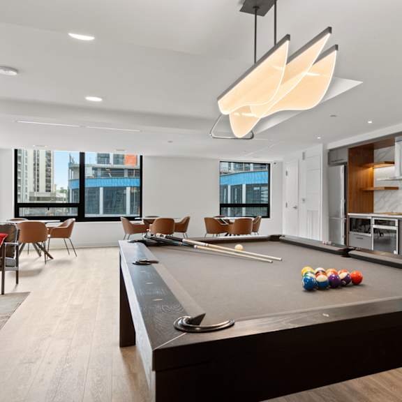 a pool table in a room with a view of the city.