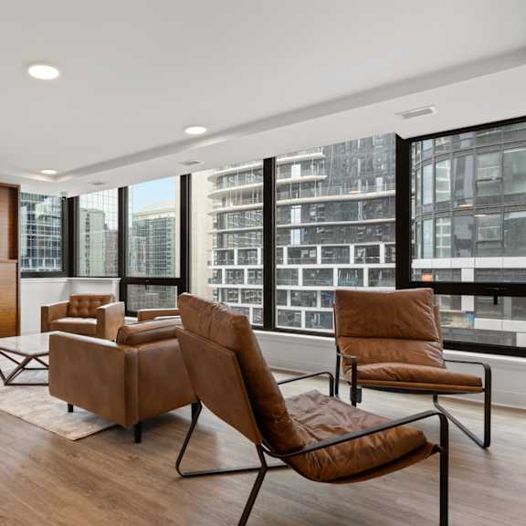 a modern living room with brown leather chairs and a wooden entertainment center.