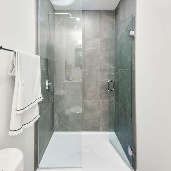 a bathroom with a shower and a sink and a towel