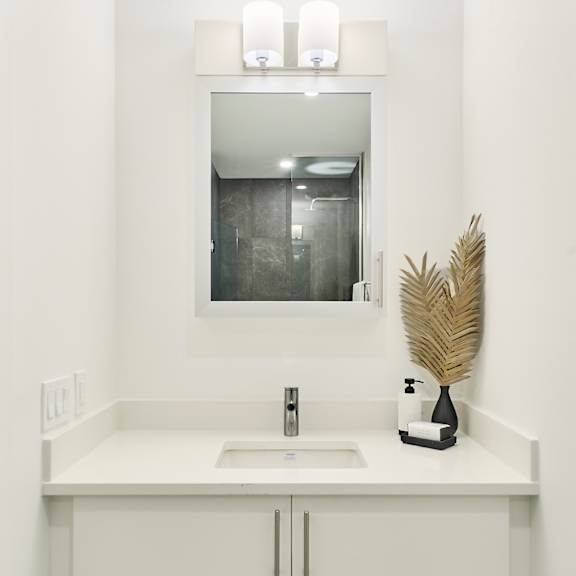 a white bathroom with a sink and a mirror