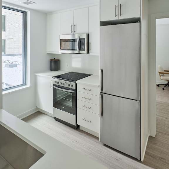 a kitchen with white cabinets and stainless steel appliances
