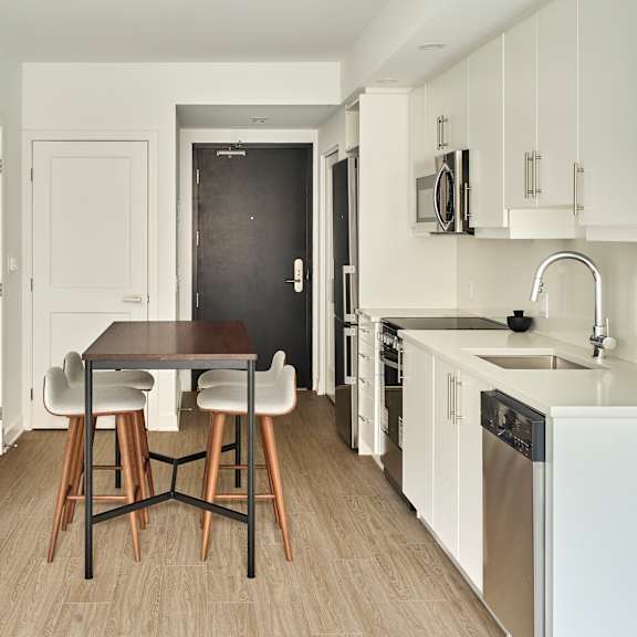 a kitchen with white cabinets and a wooden table and chairs