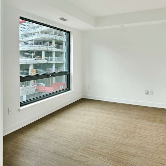 an empty room with white walls and a large window