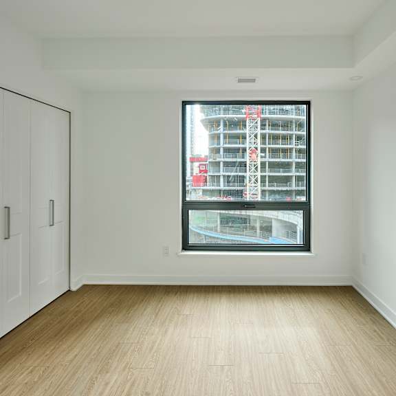 an empty room with a large window and white walls