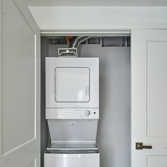 a white washer and dryer in a white closet