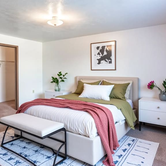 a bedroom with a bed, nightstand, and a rug.