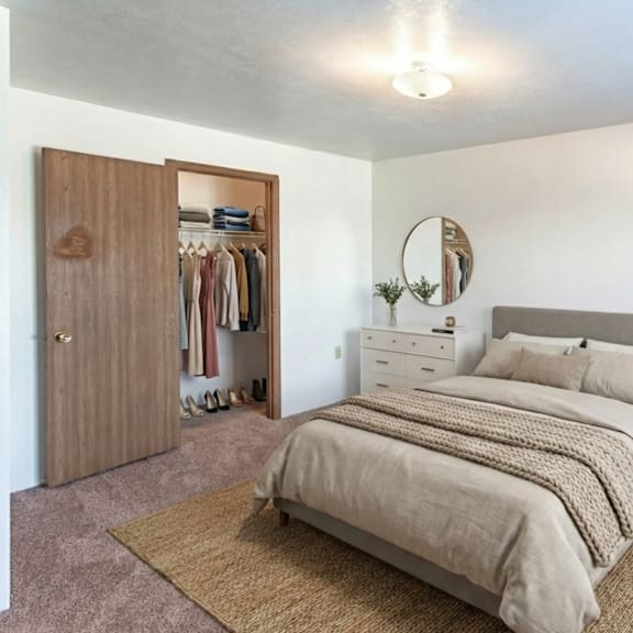 a bedroom with a large bed, a chair, and a wardrobe.