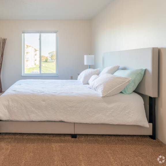 a bedroom with a bed, dresser, and window.