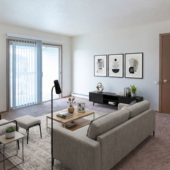 a living room with a grey couch, a chair, a small table with a vase and a plant on it, a bookshelf with a plant on top, and pictures on the wall.
