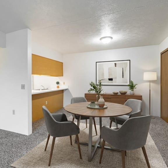 a modern dining room with a round table and grey chairs.