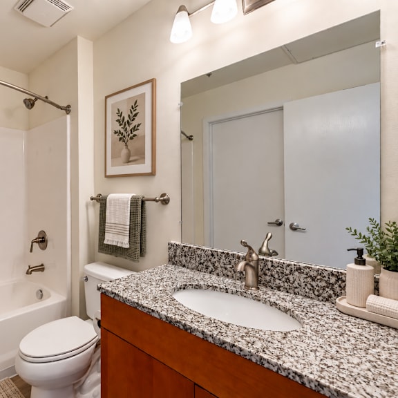 a bathroom with a toilet, sink, and shower.