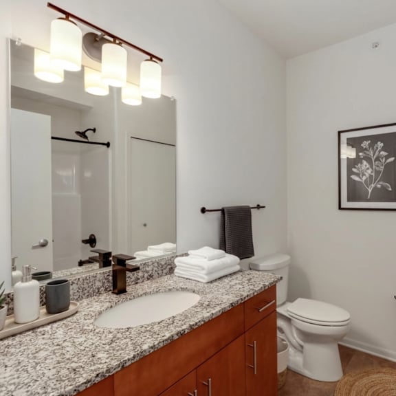 a bathroom with a toilet, sink, and mirror.
