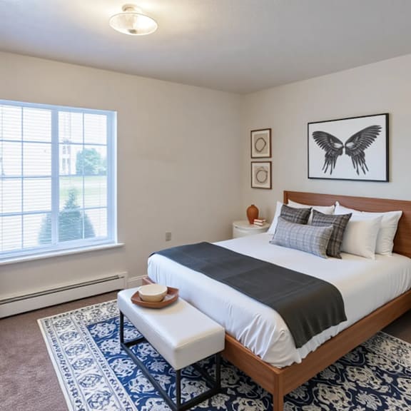 a bedroom with a large bed and a window with blinds.