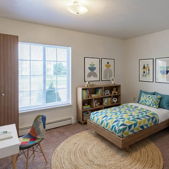 a bedroom with a bed, chair, and bookshelf.
