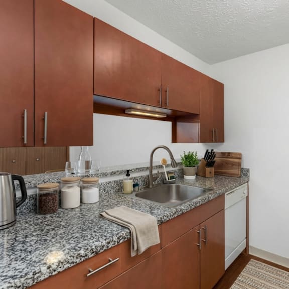 a kitchen with brown cabinets and a granite countertop.