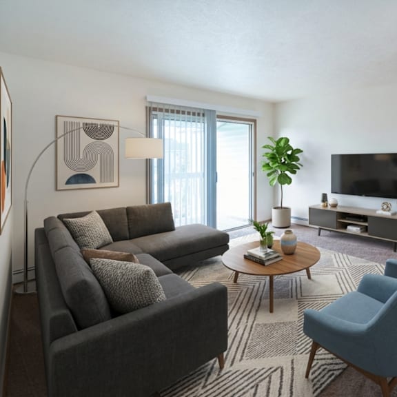 a living room with a grey couch, blue chairs, and a flat screen tv.