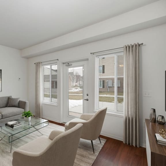 a living room with a grey sofa, a glass coffee table, and a painting on the wall.