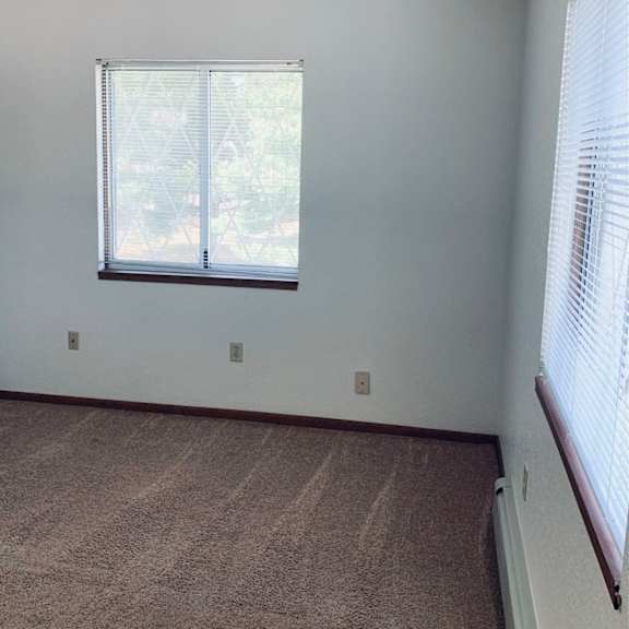an empty room with a window and a carpet
