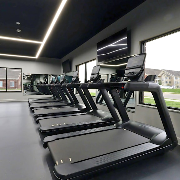 a gym with treadmills and a television.