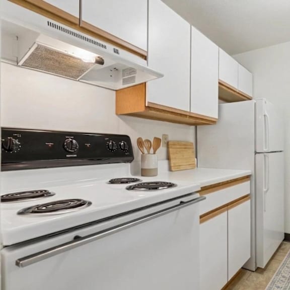 a kitchen with white appliances and wooden accents.