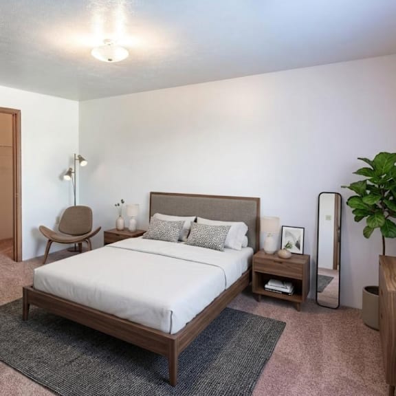 a bedroom with a bed, nightstand, and chair.