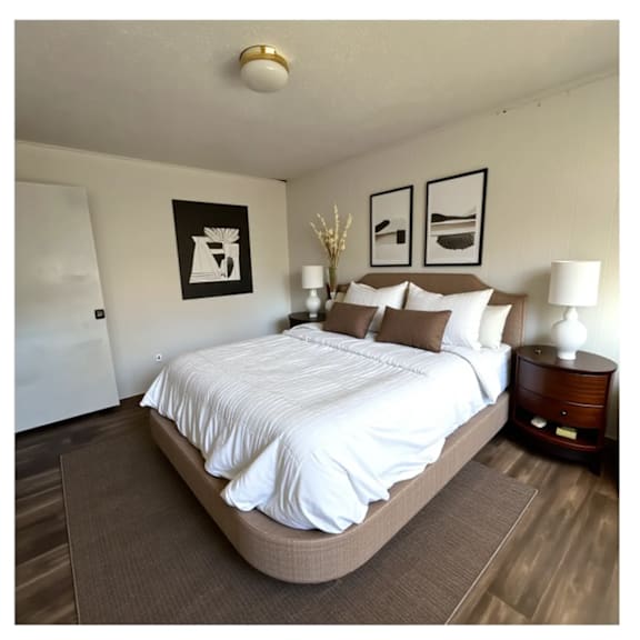 a bedroom with a large bed and two framed pictures on the wall.