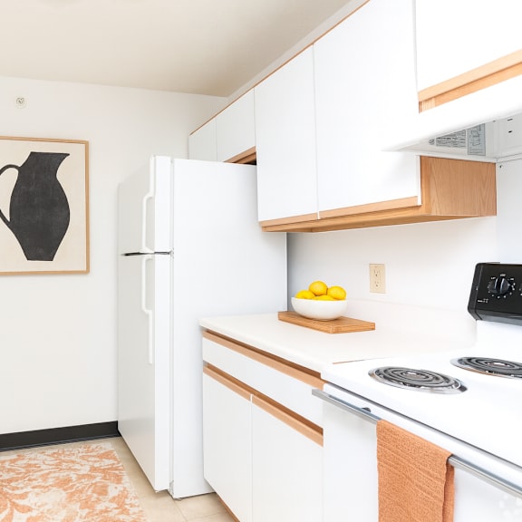 a kitchen with white cabinets and a black pitcher on the wall.