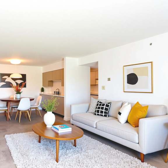 a living room with a grey couch, a coffee table, and a television.