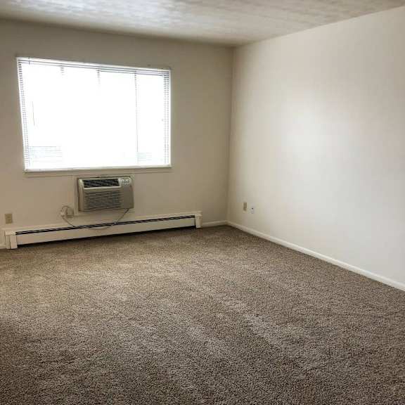 an empty room with a window and a radiator