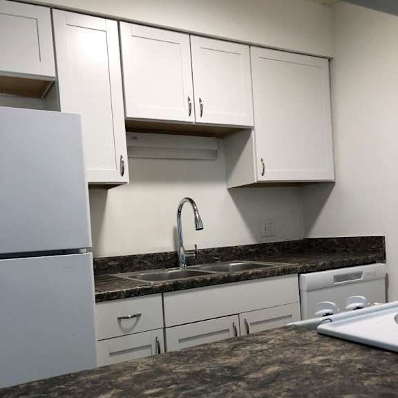 a kitchen with white cabinets and a granite counter top